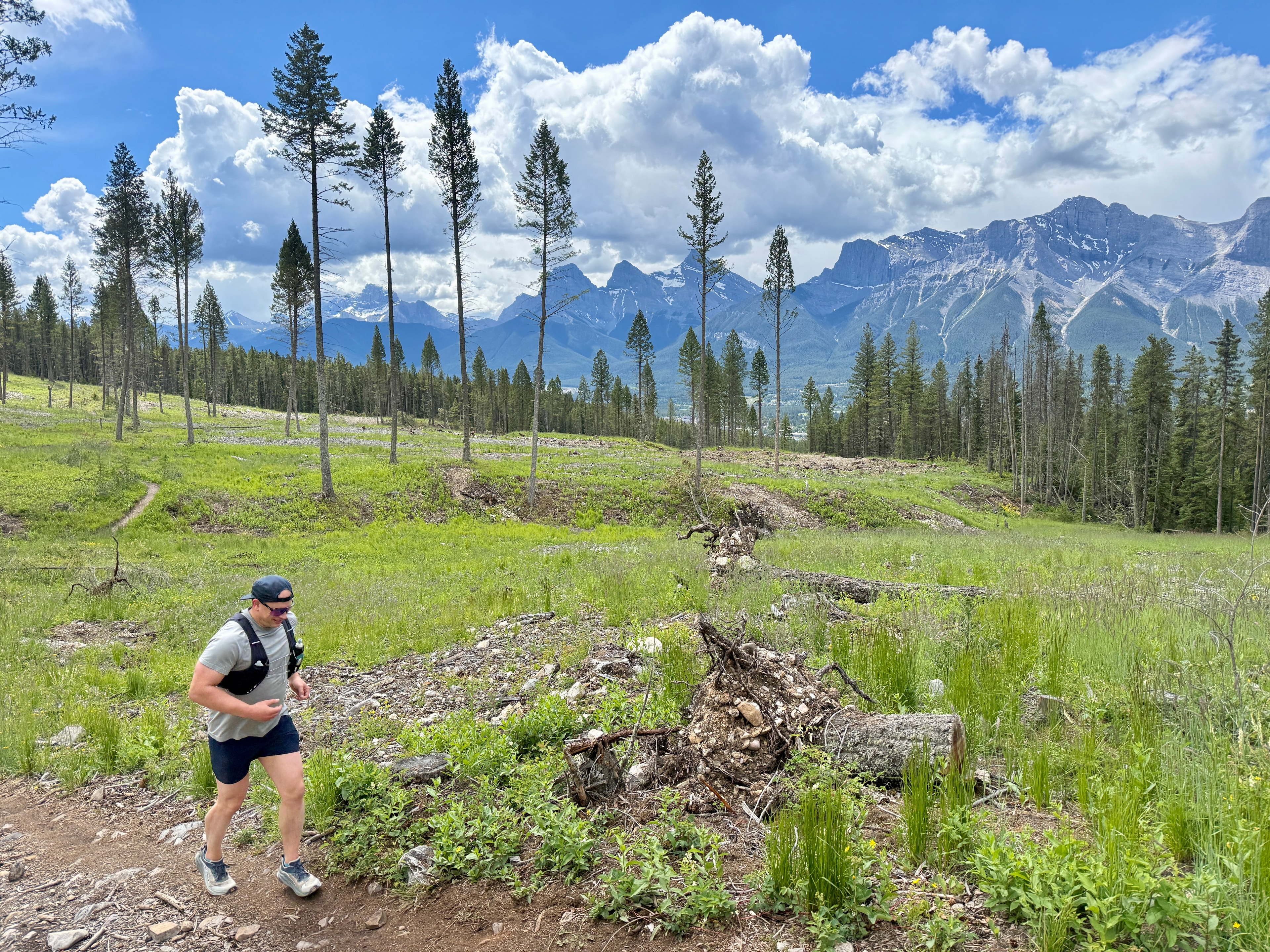 Runner on a forest trail with Canmore mountain backdrop